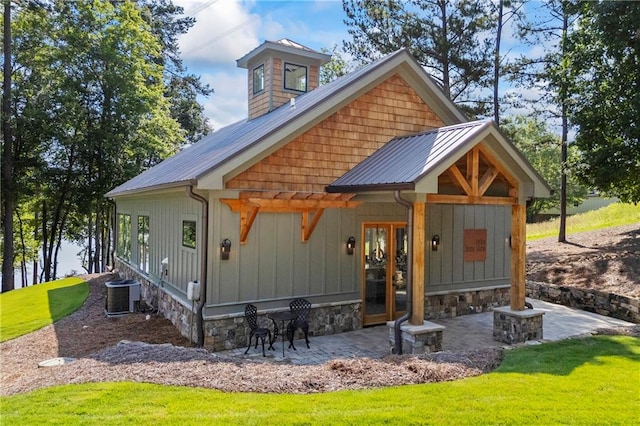 1132 N Edgewater Trl, Toccoa, GA 30577 - view of front facade featuring board and batten siding, a metal roof, a front yard, and a patio area