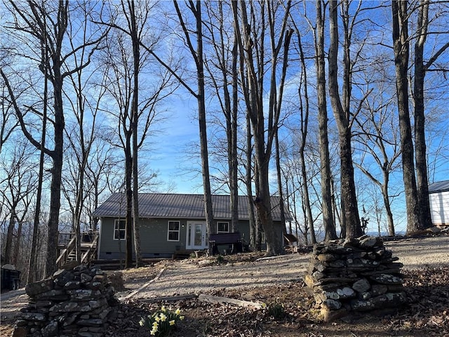 view of front of house with crawl space and metal roof