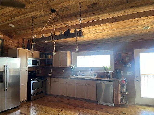 kitchen with stainless steel appliances, wood-type flooring, a sink, and wood ceiling