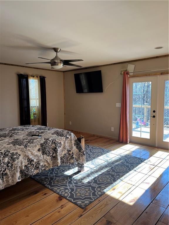 bedroom with access to exterior, wood-type flooring, and ceiling fan