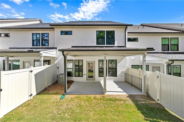 rear view of property with a patio and a lawn