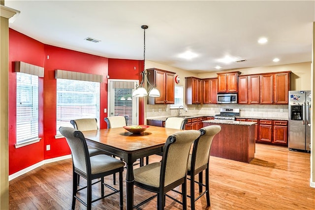 dining area with sink and light hardwood / wood-style flooring