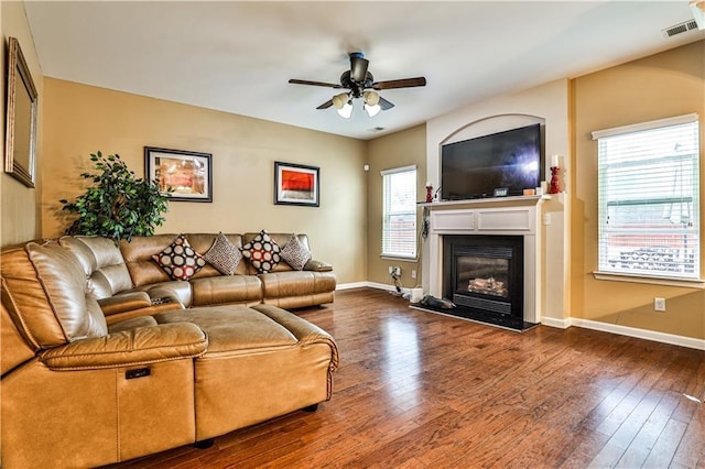 living room featuring dark wood-type flooring and ceiling fan