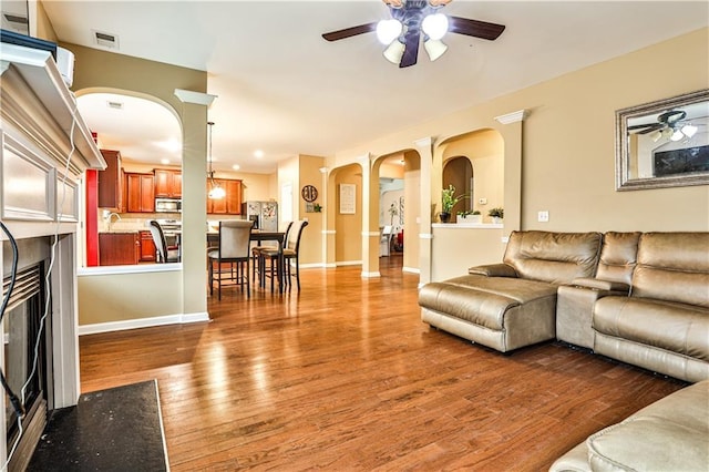 living room with hardwood / wood-style flooring, ceiling fan, and sink