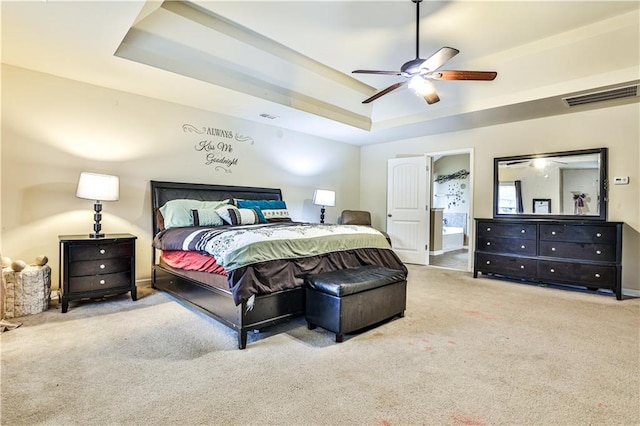 carpeted bedroom featuring ceiling fan and a tray ceiling