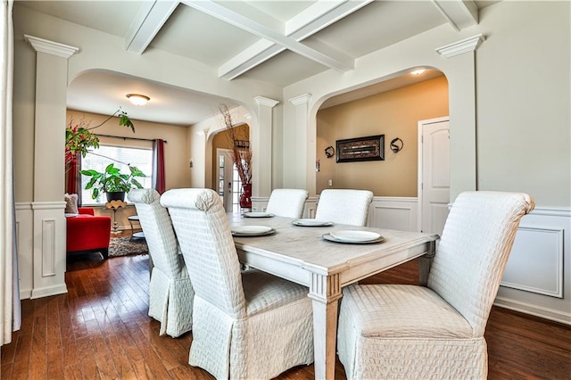 dining room featuring beamed ceiling, dark wood-type flooring, and decorative columns