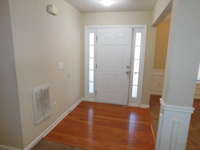 foyer with ornate columns and hardwood / wood-style floors