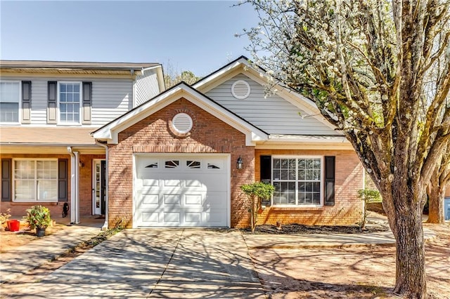 traditional home featuring a garage, brick siding, and driveway