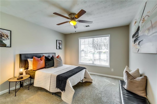 carpeted bedroom with a ceiling fan, visible vents, and baseboards