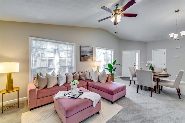 living room featuring lofted ceiling, ceiling fan with notable chandelier, baseboards, and light colored carpet