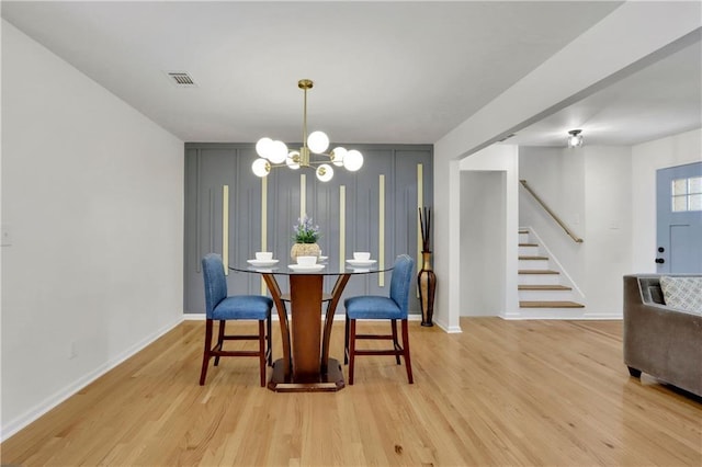 6914 Fairway Trl, Austell, GA 30168 - dining space with visible vents, baseboards, stairs, light wood-type flooring, and a notable chandelier