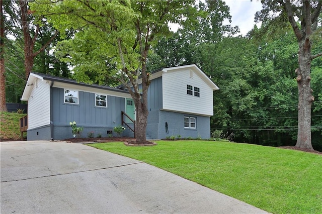 tri-level home with a front yard, board and batten siding, and brick siding