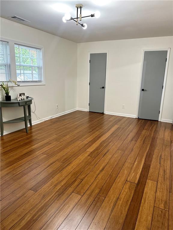 6914 Fairway Trl, Austell, GA 30168 - unfurnished room featuring dark wood-type flooring, baseboards, a chandelier, and visible vents