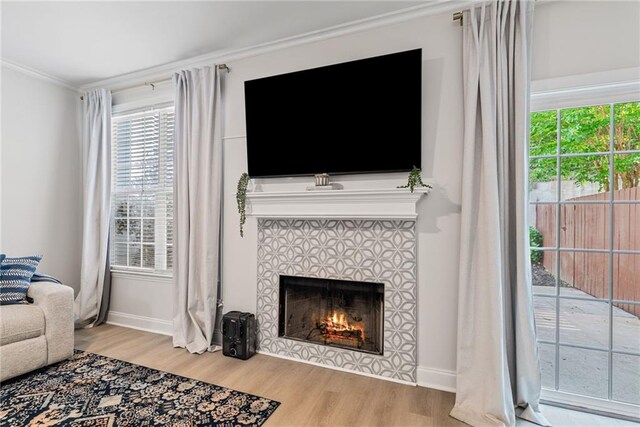 3088 Steeplechase Dr, Alpharetta, GA 30004 - living room featuring crown molding, a healthy amount of sunlight, wood finished floors, and a tile fireplace