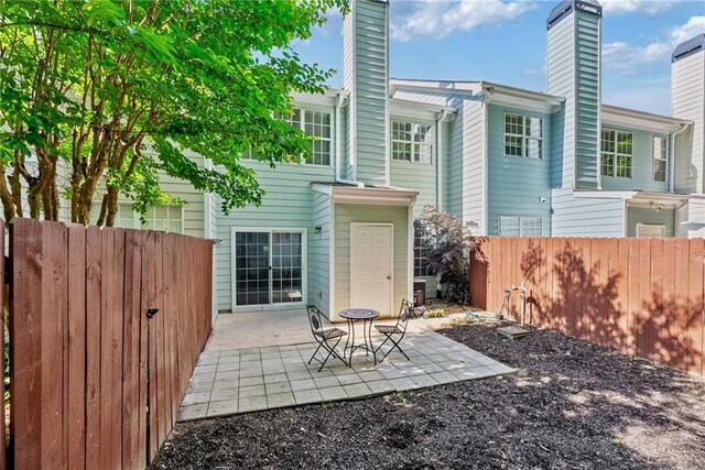 3088 Steeplechase Dr, Alpharetta, GA 30004 - rear view of house with a patio, fence, and a chimney