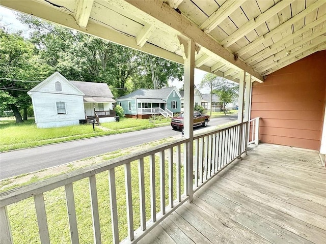 wooden terrace featuring a yard and a porch