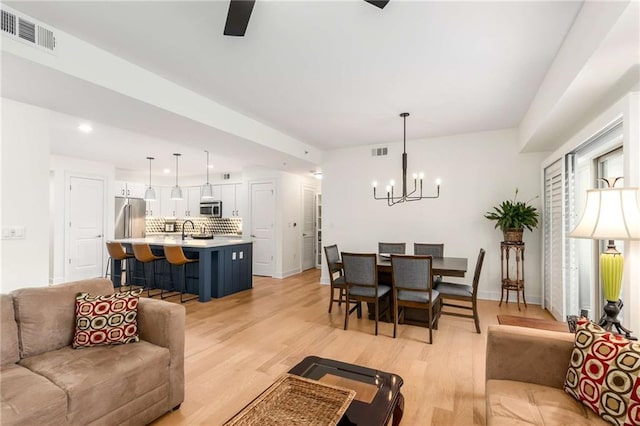 200 River Vista Dr Unit 426, Atlanta, GA 30339 - living area with light wood-style flooring, visible vents, a notable chandelier, and baseboards