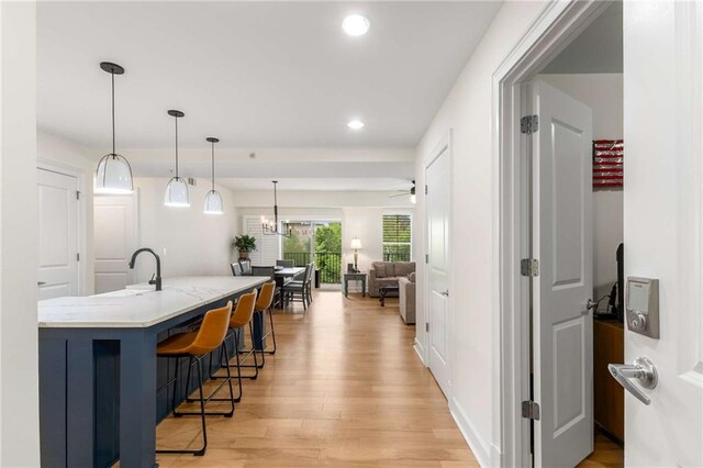 200 River Vista Dr Unit 426, Atlanta, GA 30339 - kitchen with a kitchen breakfast bar, light wood-type flooring, recessed lighting, an island with sink, and hanging light fixtures