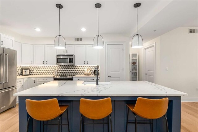 200 River Vista Dr Unit 426, Atlanta, GA 30339 - kitchen with appliances with stainless steel finishes, visible vents, tasteful backsplash, and white cabinets