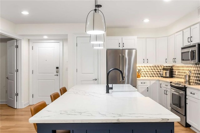 200 River Vista Dr Unit 426, Atlanta, GA 30339 - kitchen with tasteful backsplash, light wood-style flooring, appliances with stainless steel finishes, white cabinets, and a sink