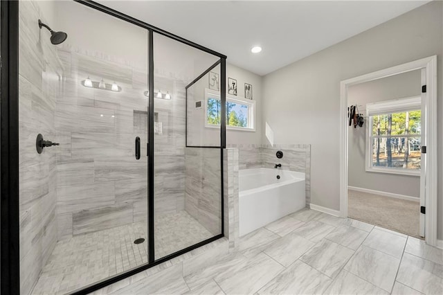 bathroom featuring a healthy amount of sunlight and separate shower and tub