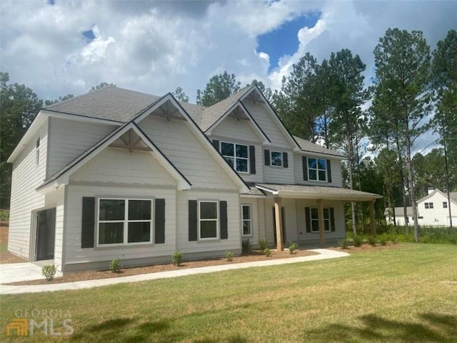 view of front facade with a garage, a porch, and a front lawn