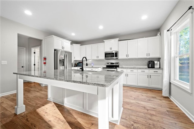 kitchen featuring white cabinetry, an island with sink, appliances with stainless steel finishes, and sink