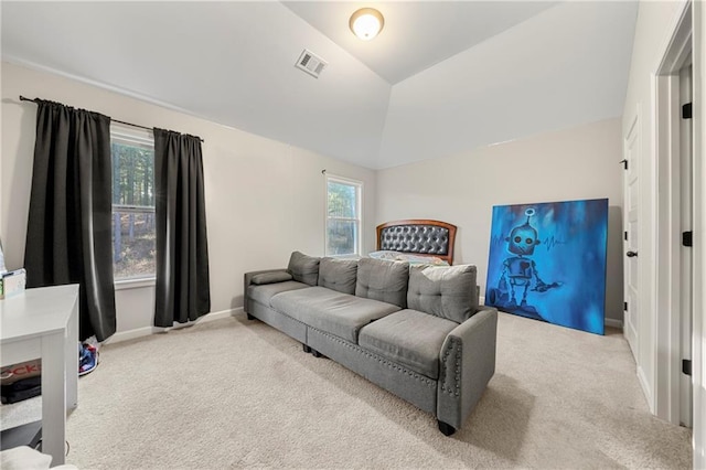 bedroom with lofted ceiling, multiple windows, and light colored carpet