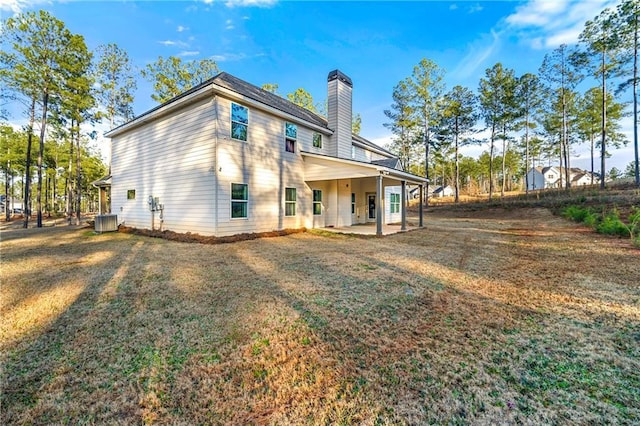 rear view of property featuring a patio, a yard, and cooling unit