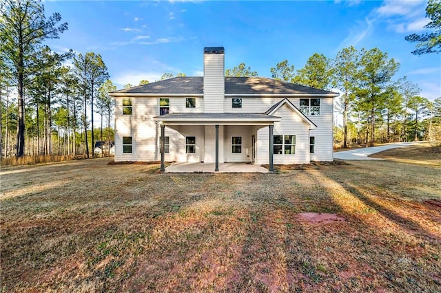 back of property with a patio and a lawn