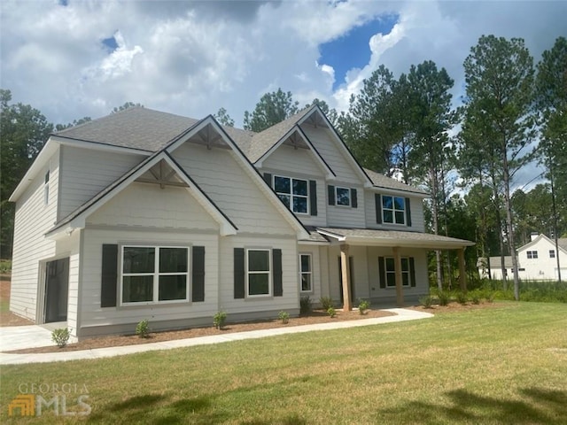 view of front facade featuring a garage, covered porch, and a front yard