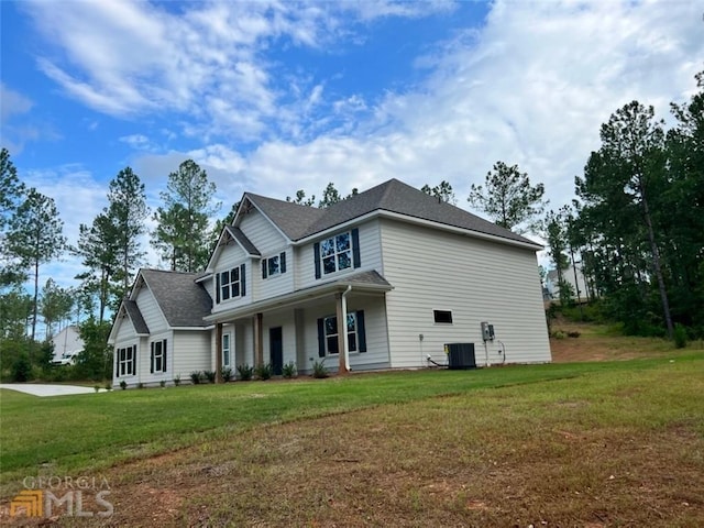 view of front of home with cooling unit and a front yard