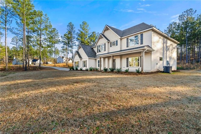 view of front of home with central AC unit and a front lawn