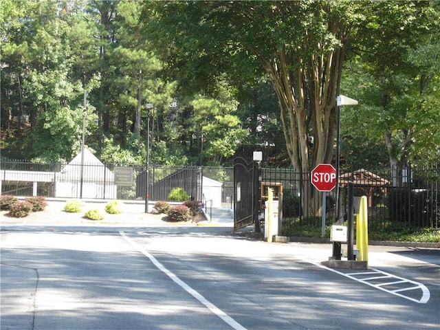 4018 Woodridge Way, Tucker, GA 30084 - view of road with a gate, street lighting, and traffic signs