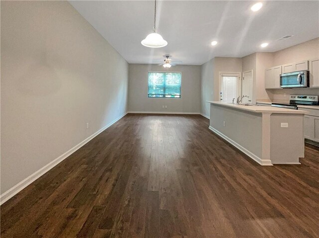 kitchen with stainless steel appliances, hanging light fixtures, an island with sink, dark wood-type flooring, and ceiling fan