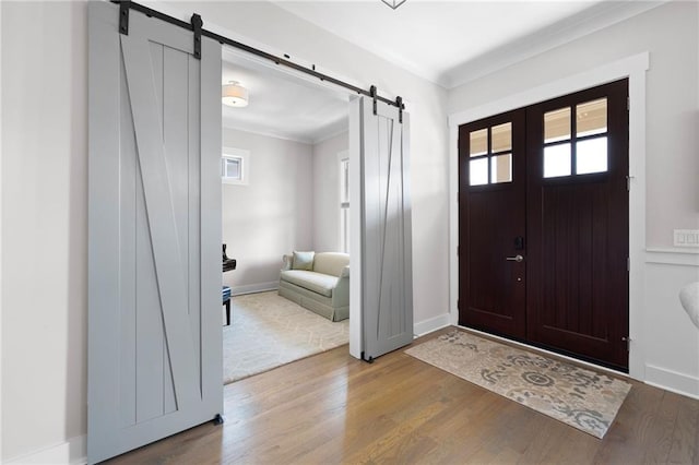 168 Brighton Blvd, Woodstock, GA 30188 - entryway featuring a barn door, plenty of natural light, ornamental molding, and wood finished floors