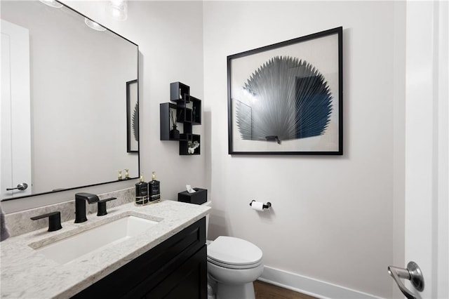 168 Brighton Blvd, Woodstock, GA 30188 - half bathroom featuring toilet, vanity, baseboards, and wood finished floors