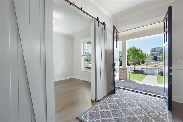 168 Brighton Blvd, Woodstock, GA 30188 - foyer with a barn door, ornamental molding, wood finished floors, and baseboards