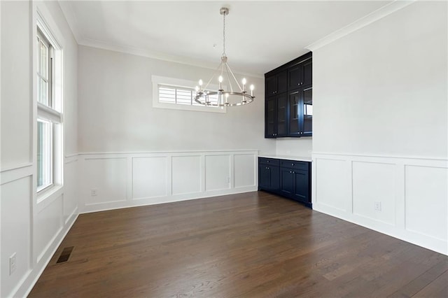 168 Brighton Blvd, Woodstock, GA 30188 - unfurnished dining area with a decorative wall, a chandelier, dark wood-type flooring, ornamental molding, and a wainscoted wall