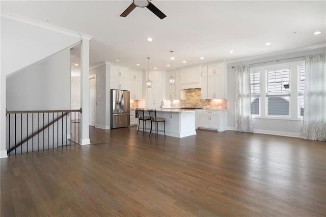 168 Brighton Blvd, Woodstock, GA 30188 - unfurnished living room featuring a ceiling fan, dark wood finished floors, recessed lighting, baseboards, and crown molding