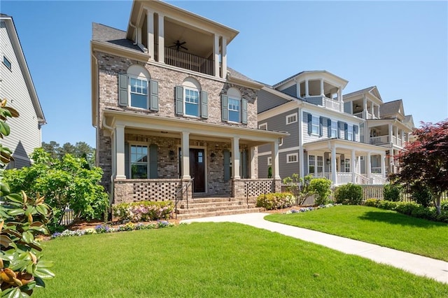 168 Brighton Blvd, Woodstock, GA 30188 - view of front facade with brick siding, a front yard, covered porch, a ceiling fan, and a balcony
