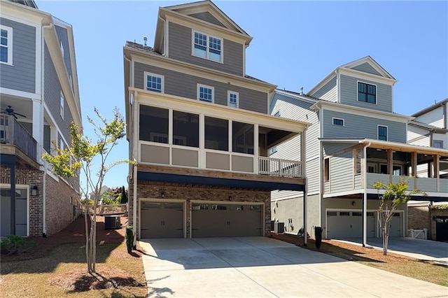 168 Brighton Blvd, Woodstock, GA 30188 - view of front facade with an attached garage, concrete driveway, central air condition unit, and a sunroom