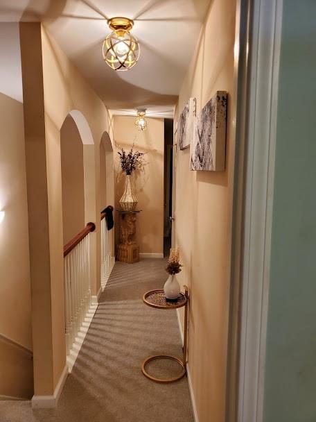 hallway with baseboards and carpet flooring
