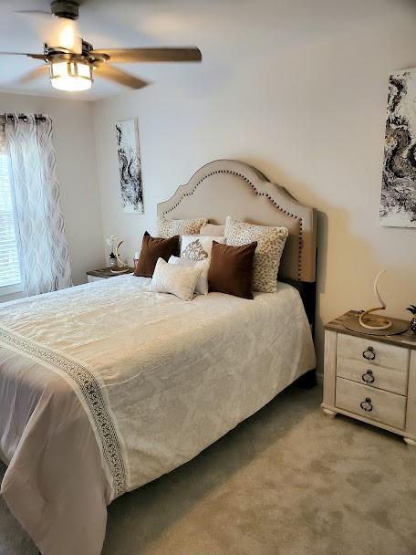 bedroom featuring ceiling fan and light carpet