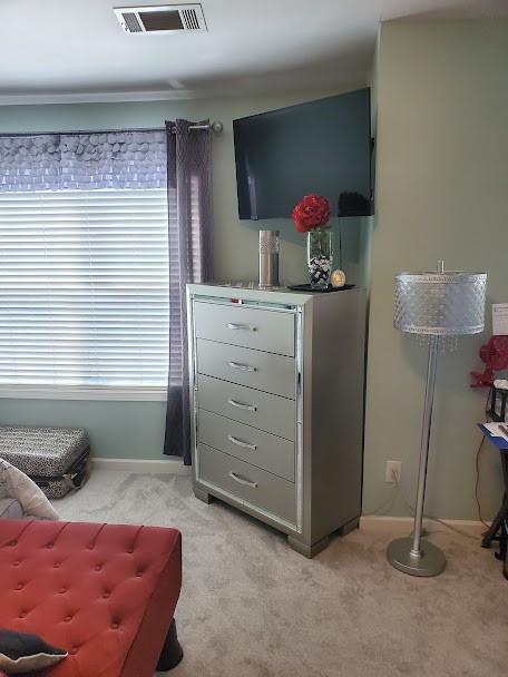 living area featuring light colored carpet, baseboards, and visible vents