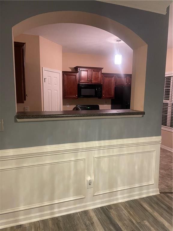 2118 Burns View Ln, Lawrenceville, GA 30044 - kitchen with black appliances, arched walkways, dark brown cabinets, wood finished floors, and wainscoting