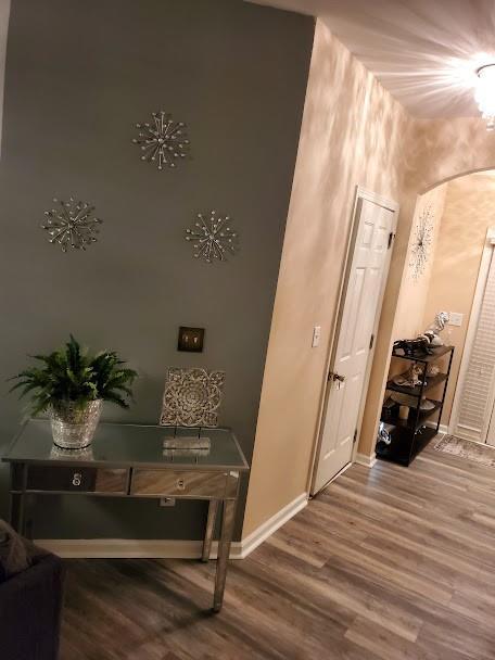 hallway featuring baseboards and wood finished floors