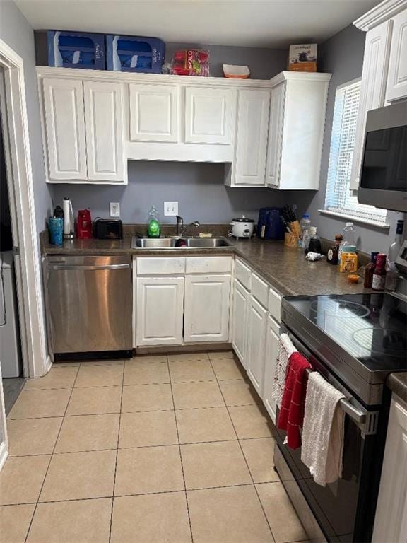 4701 Flat Shoals Rd Unit 37E, Union City, GA 30291 - kitchen featuring appliances with stainless steel finishes, a sink, white cabinets, light tile patterned floors, and dark countertops