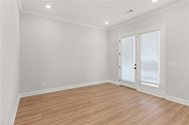 spare room with plenty of natural light, ornamental molding, and light wood-type flooring