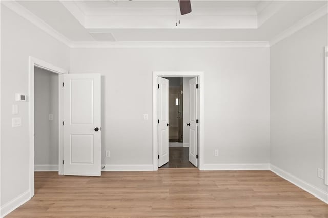 unfurnished room with ceiling fan, ornamental molding, a tray ceiling, and light hardwood / wood-style floors